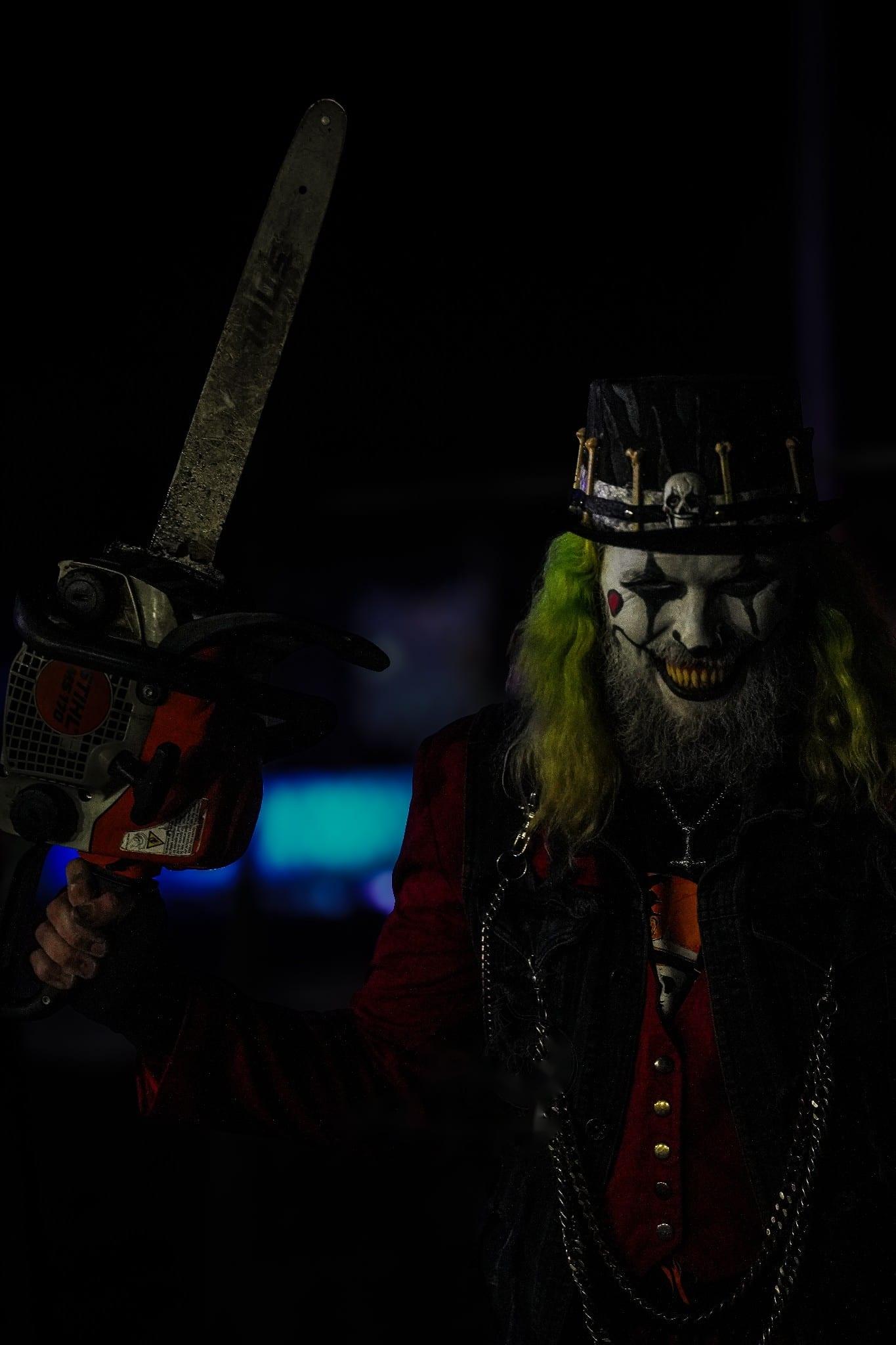 A gas-masked figure under purple light