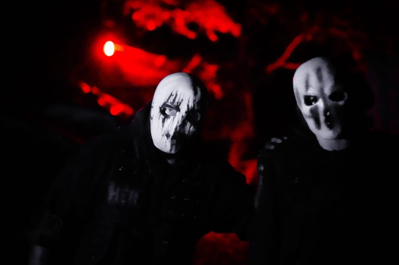 Two figures in pale masks
