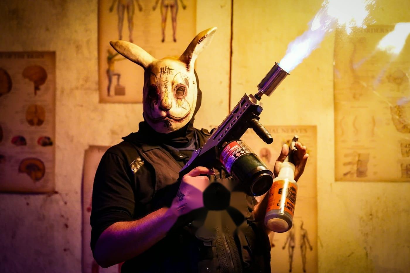 A masked performer with a flame prop